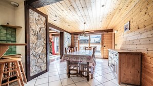 Un intérieur en bois comprenant une table à manger, des chaises et un coin cuisine.