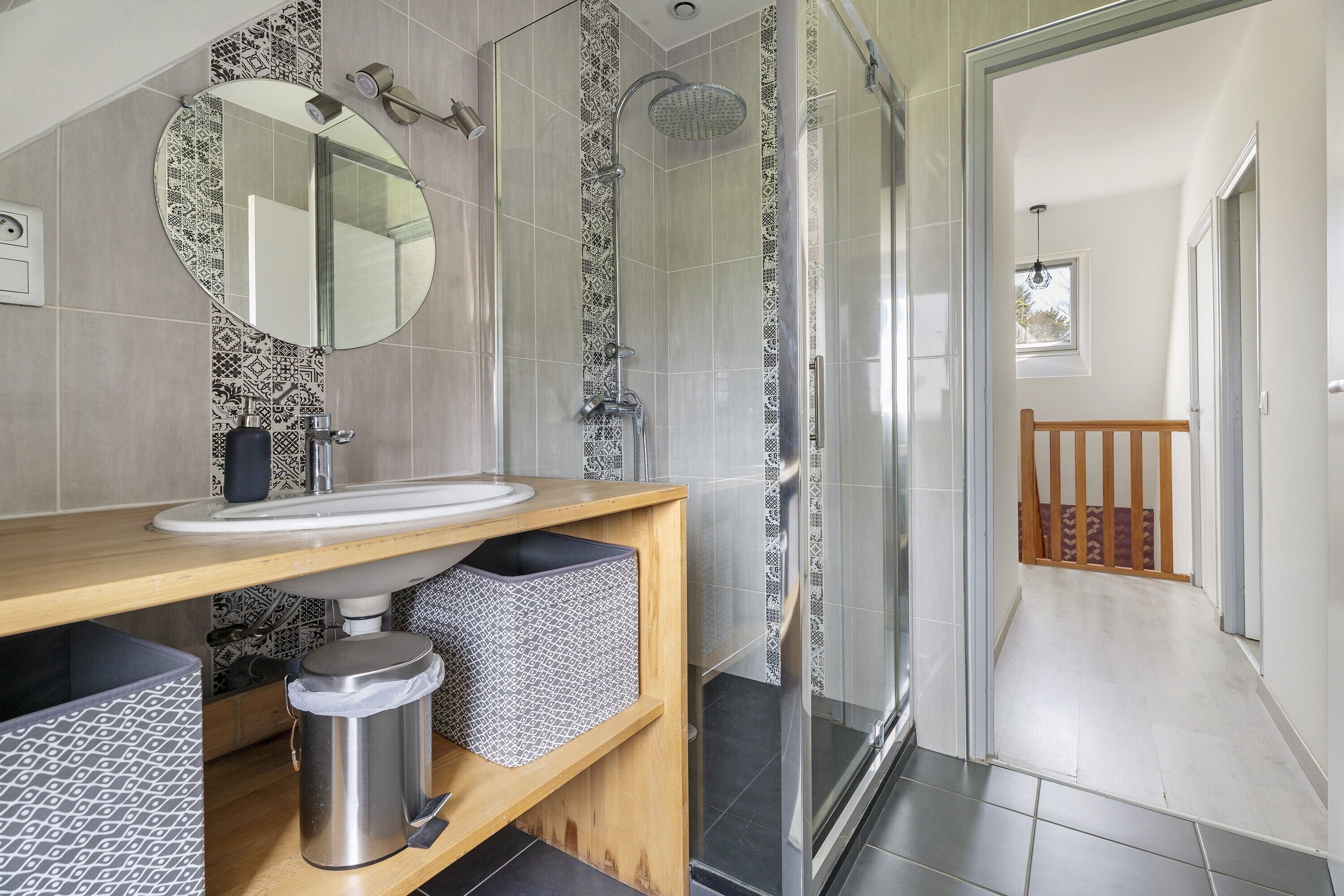 A modern bathroom with a shower, sink, and mirror.