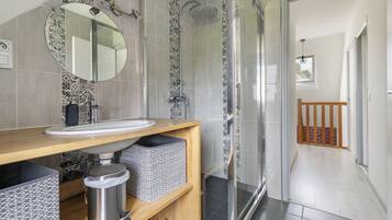 A modern bathroom with a shower, sink, and mirror.