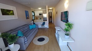 A modern living room with a sofa, a small table, and a potted plant. - Holiday Apartment 'Amazing' with Sea View, Shared Pool and Wi-Fi (Mogán)