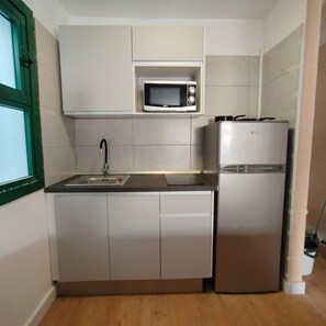 A compact kitchen with a sink, a microwave, and a refrigerator. - Holiday Apartment 'Amazing' with Sea View, Shared Pool and Wi-Fi (Mogán)