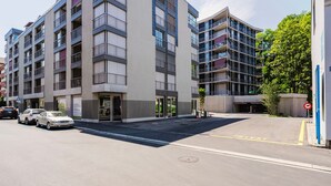 A multi-story building with a modern architectural design, featuring balconies and large windows.