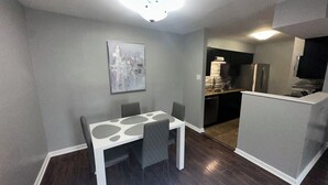 Una cocina compacta con refrigerador, lavavajillas y encimera.