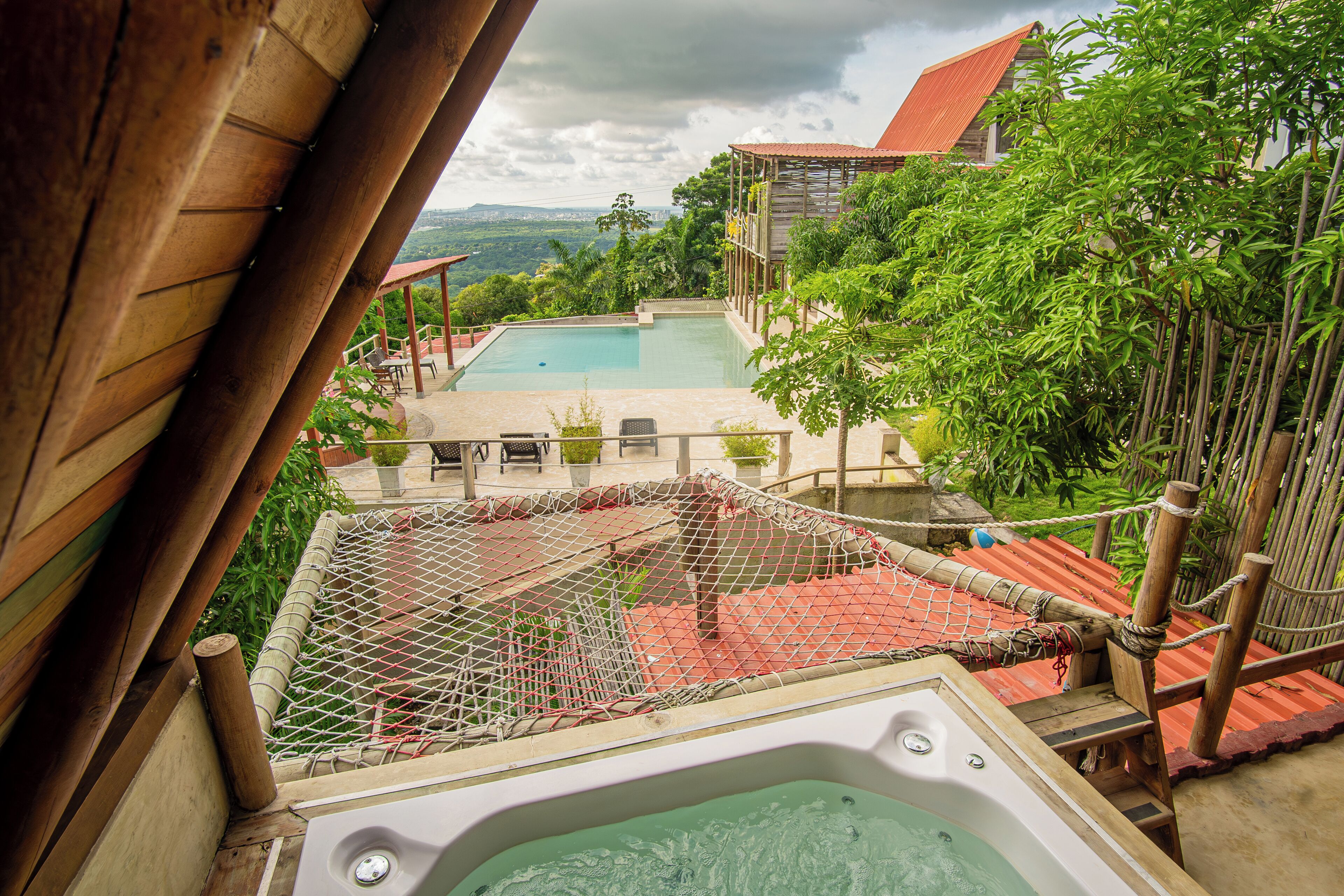 A hot tub, a pool, and a view of a mountainous landscape.