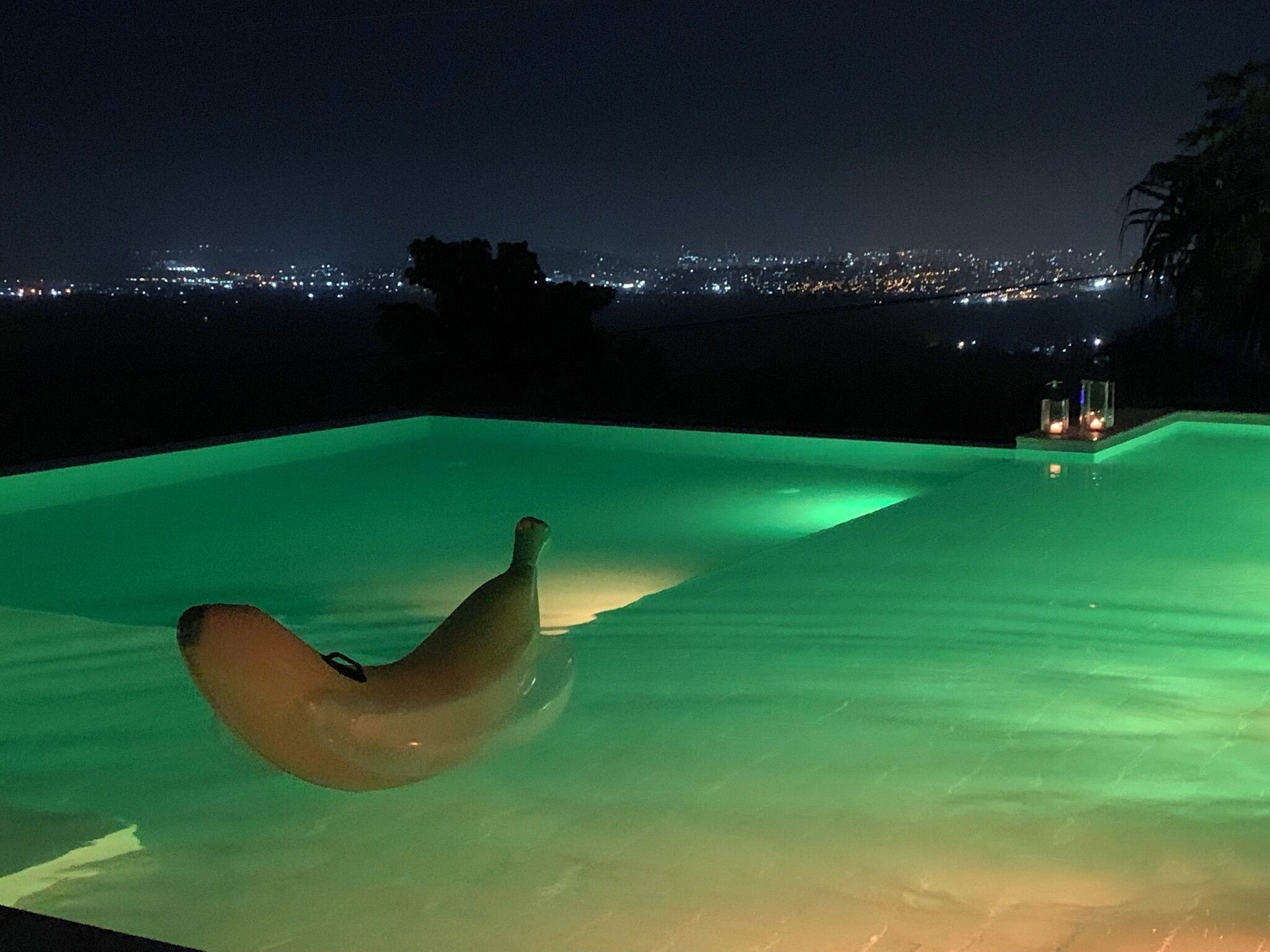 An infinity pool with a view of a cityscape at night.
