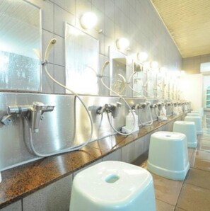 Public restroom with stainless steel sinks, mirrors, and soap dispensers.