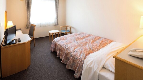 Cozy retreat with a single bed, desk, and chair, perfect for a comfortable stay.