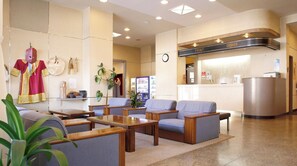 Welcome to our hotel lobby, featuring a reception area, comfortable seating, and a decorative wall showcasing cultural items.