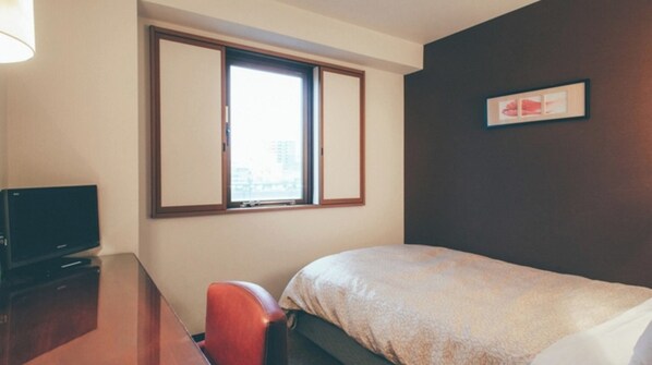 Enjoy a city view from the comfort of this cozy room, featuring a single bed, desk with TV, and a chair.