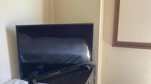 Relax in a cozy space with a flat-screen television and a comfortable bed.
