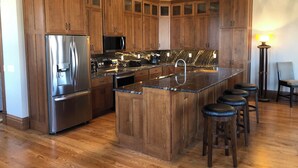 A modern kitchen with wooden cabinets, stainless steel appliances, and a marble countertop. - Spacious 2-bedroom loft above the International Owl Center in Houston, MN (Houston)