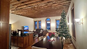 A dining area with a wooden ceiling, a Christmas tree, and a TV in the background. - Spacious 2-bedroom loft above the International Owl Center in Houston, MN (Houston)