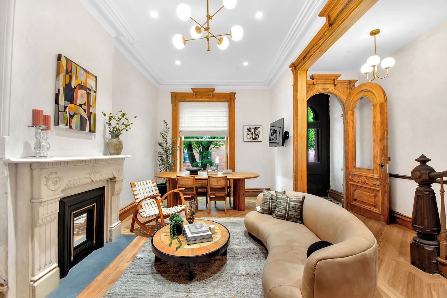 A well-lit living room with a fireplace, a dining area, and a sofa.