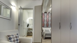 Een moderne slaapkamer met een bed, een kledingkast en een badkamer die door een open deur zichtbaar is.