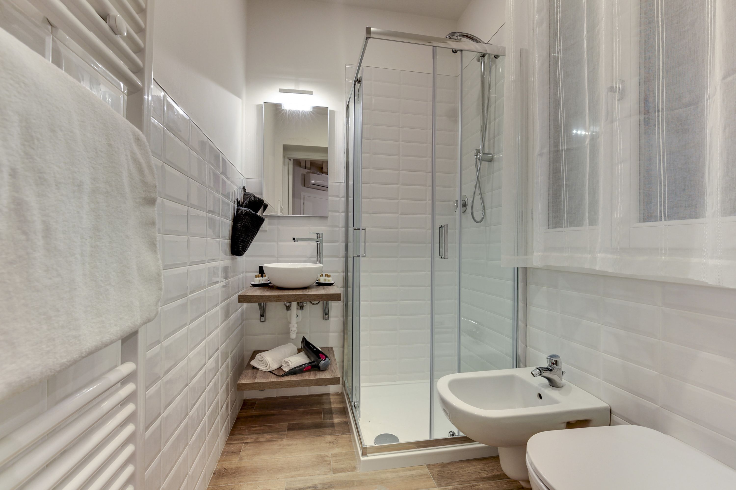 A modern bathroom with a glass shower enclosure, a sink, and a toilet.