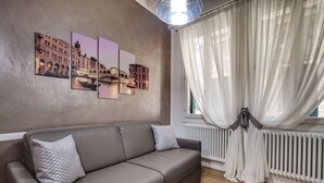 A modern living room with a brown leather sofa, a white radiator, and a window with sheer curtains. - San Marco Promenade by Wonderful Italy (Venice)