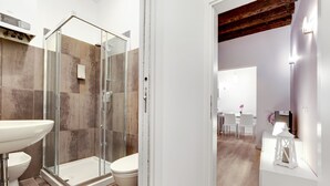 A modern bathroom with a glass shower enclosure, a white sink, and a toilet. - Ca dei Botteri 2 by Wonderful Italy (Venice)