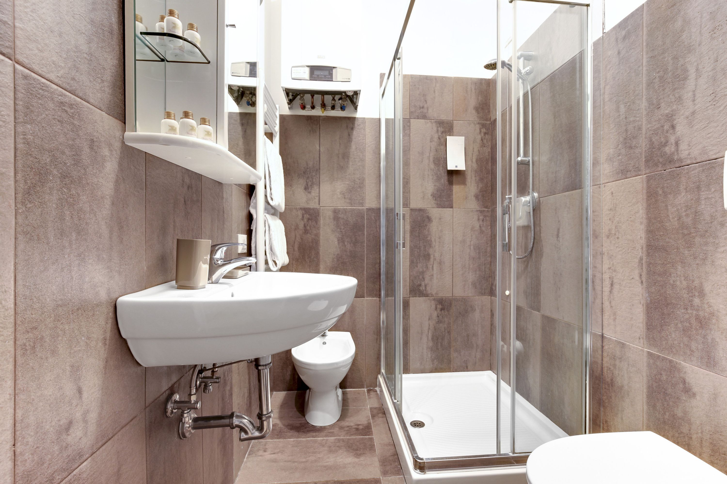 Une salle de bain moderne avec une douche à parois de verre, un lavabo blanc et des toilettes.