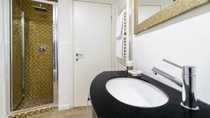 A bathroom with a black sink, chrome faucet, and a shower with a checkered tile wall. - Accademia II by Wonderful Italy (Venice)