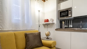 A modern kitchen with white cabinets, a microwave, and a small island with a globe and kettle. - Accademia II by Wonderful Italy (Venice)