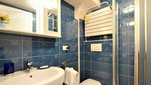 A bathroom with a white bathtub, a white toilet, and a shower area with a glass door.