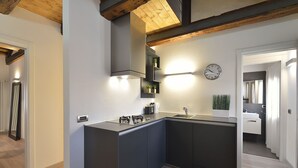 Una cocina moderna con armarios oscuros, una estufa empotrada y un reloj en la pared.