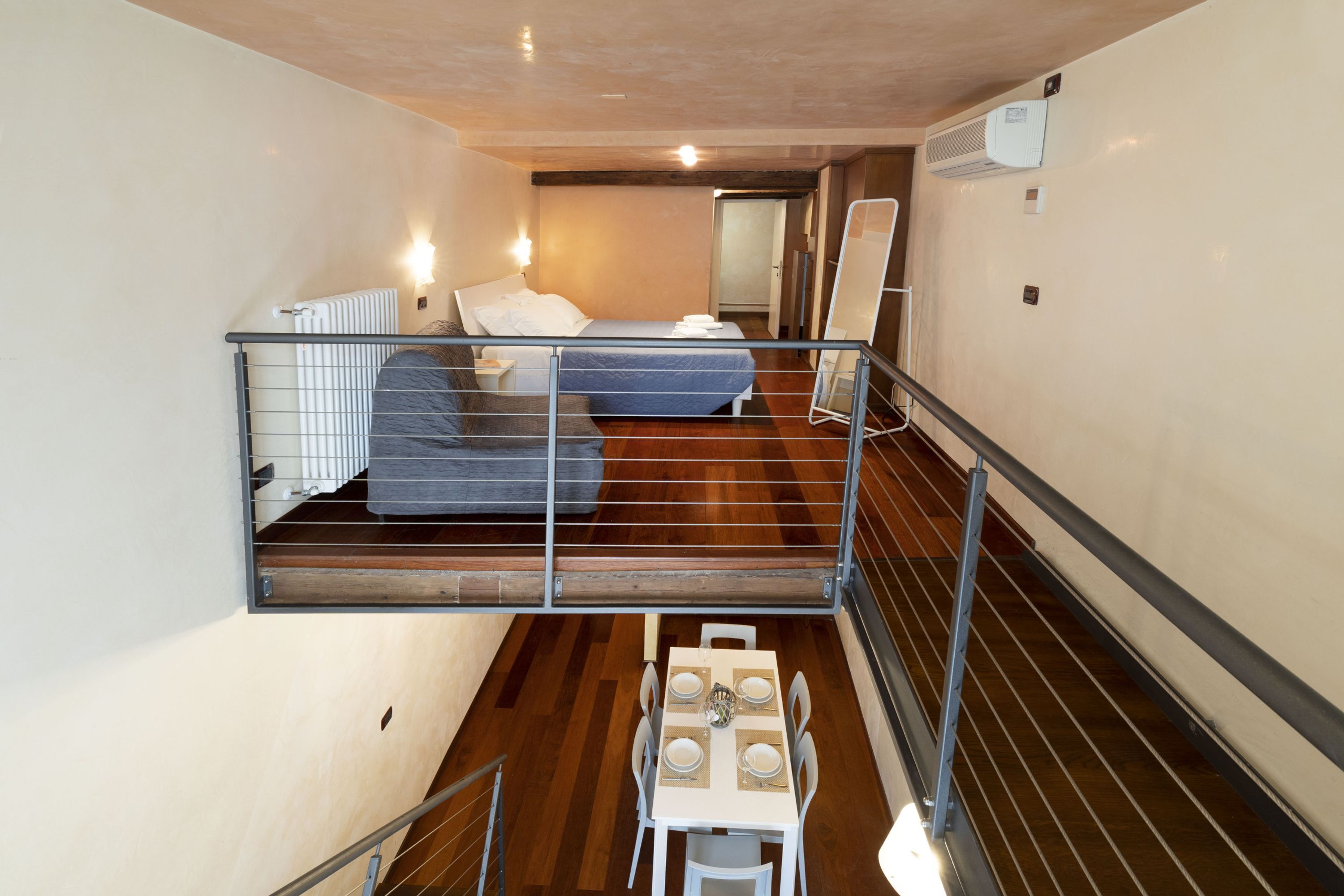 Une chambre de type dortoir, avec des lits superposés, une petite table avec des chaises et un radiateur.