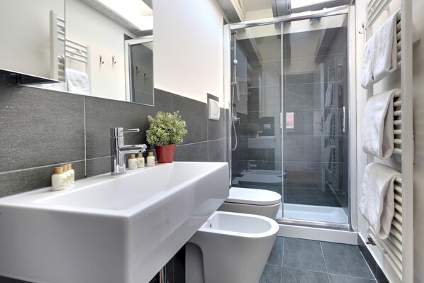 A modern bathroom with a large sink, toilet, and glass shower enclosure. - Pozzo Roverso by Wonderful Italy (Venice)