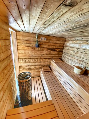 A sauna with wooden benches and a stone basin. - Villa met Sauna Ldd032 (Desna)
