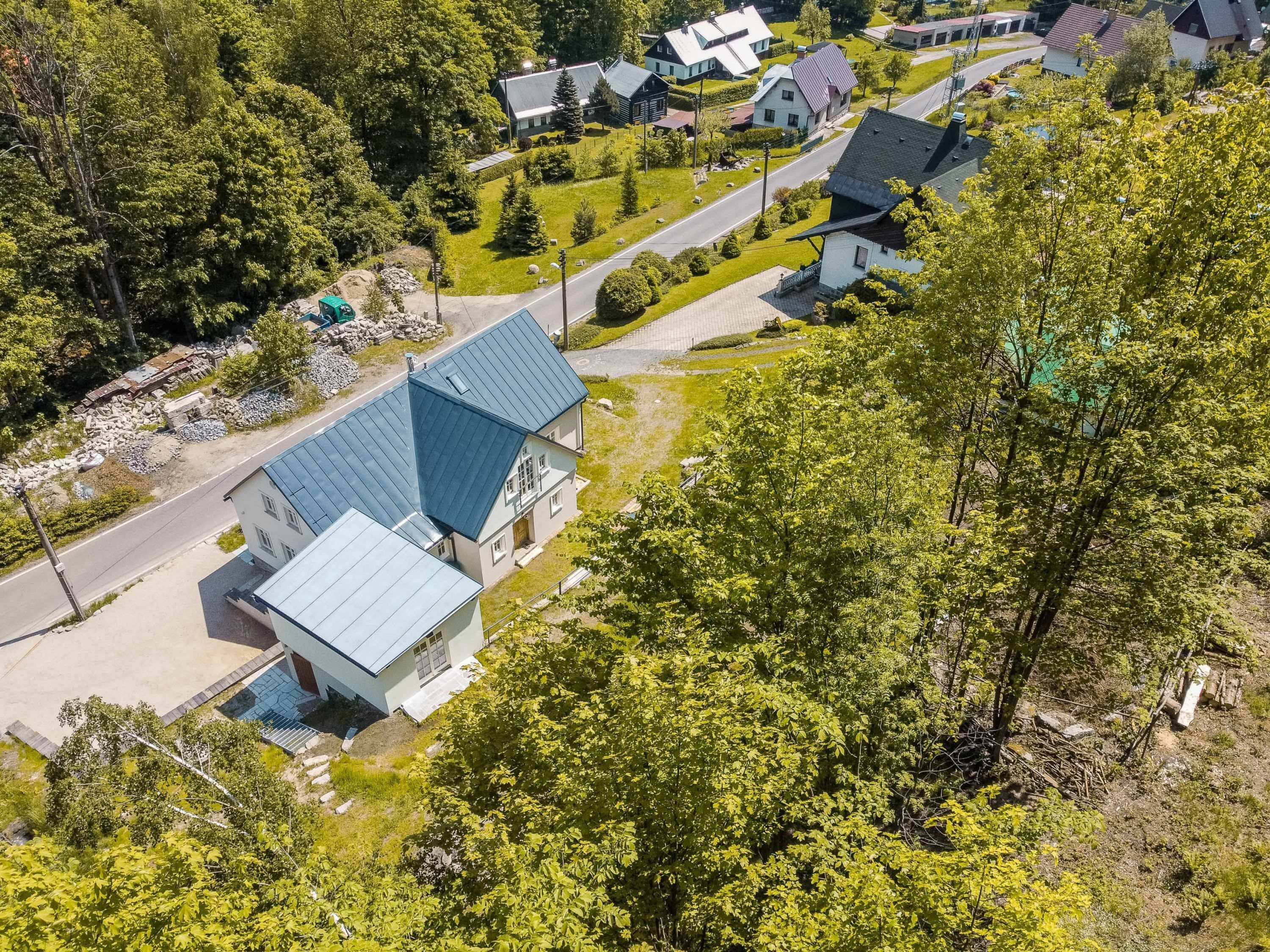 An aerial view of a residential area with houses, roads, and greenery.