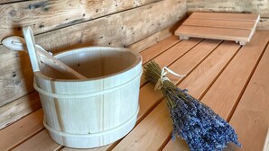 A wooden interior with a white bucket, a wooden spoon, and a bunch of dried flowers on a wooden table. - Villa met Sauna Ldd032 (Desna)