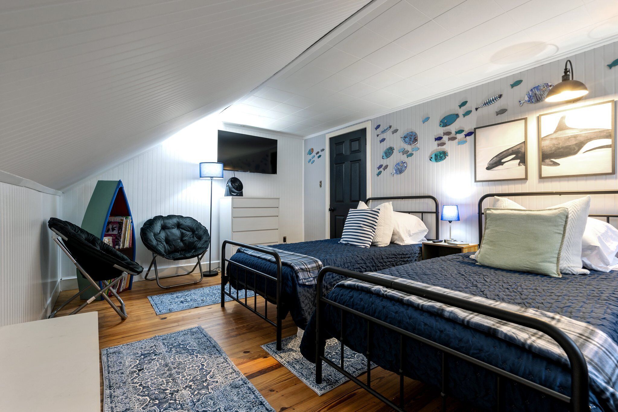 A bedroom with a bunk bed, a chair, a surfboard, and wall decorations.