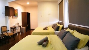A hotel room with two beds, a desk, a chair, and a TV mounted on the wall. - Cassa Kaseh Guest House (Langkawi)