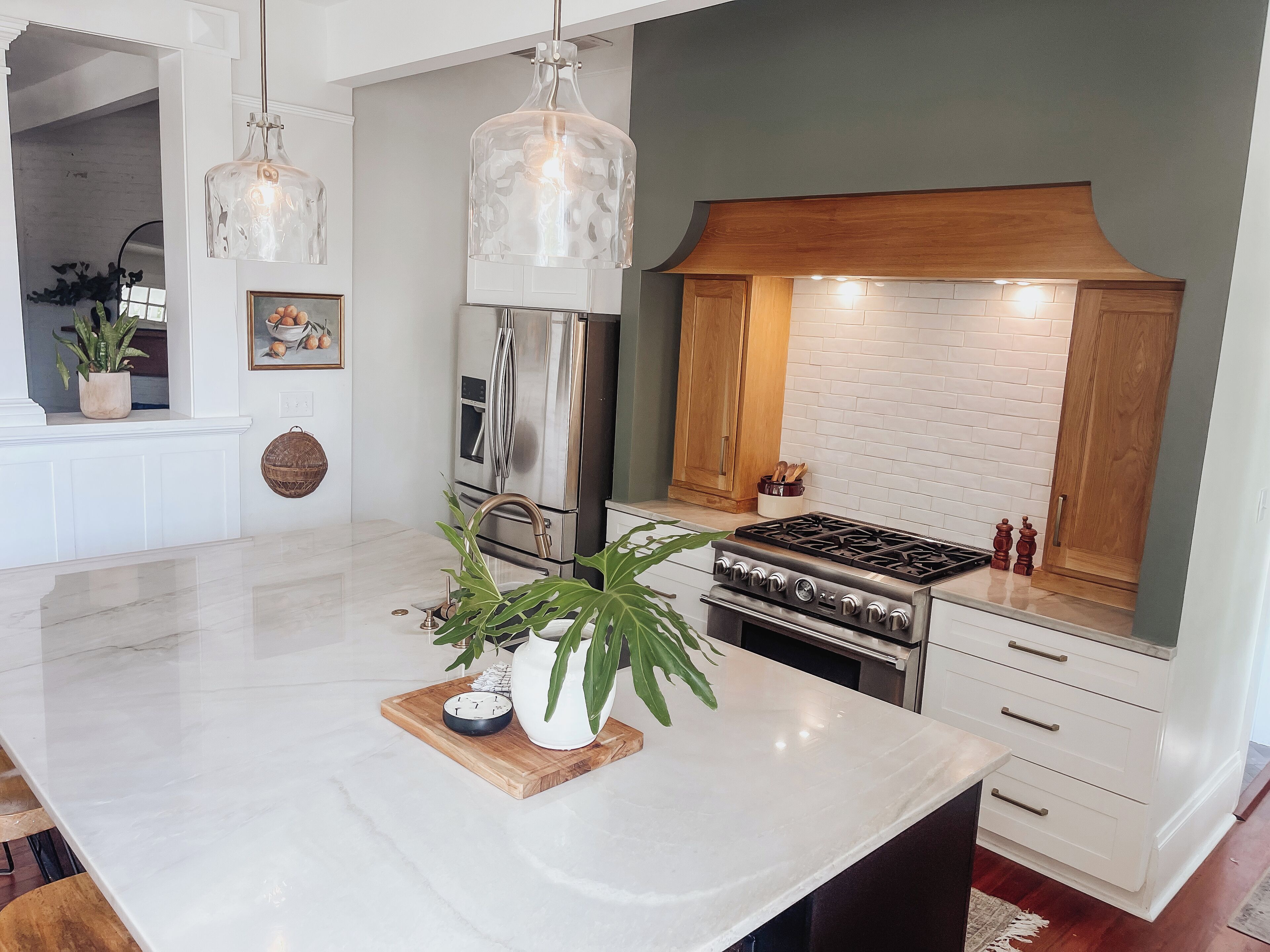 A modern kitchen with a central island, stainless steel appliances, and a white marble countertop.
