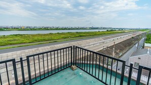 A view from a balcony overlooking a waterfront with a bridge in the distance.