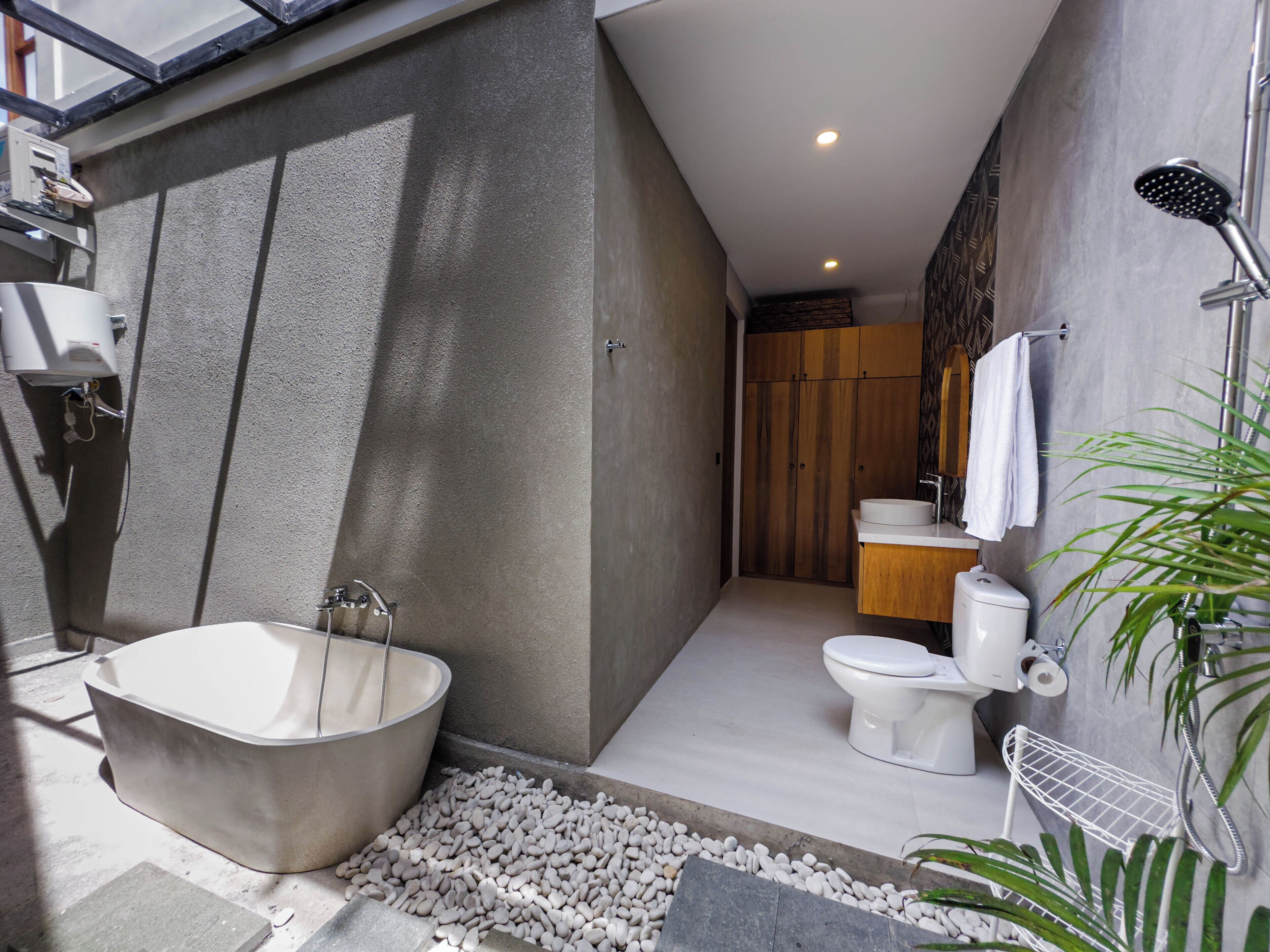 Un baño moderno con una bañera independiente, inodoro y ducha.