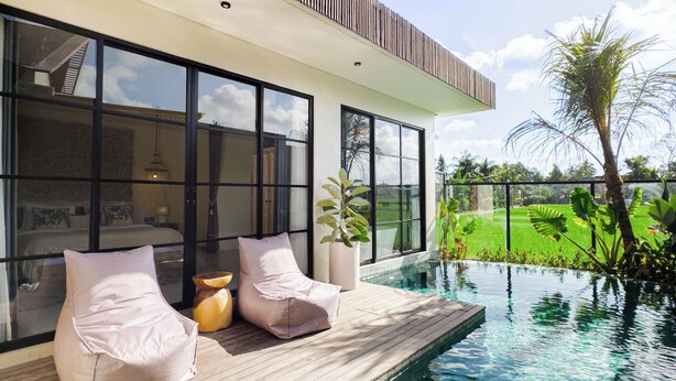 A modern house with a swimming pool, large windows, and a wooden deck.