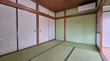 Una habitación japonesa tradicional con suelo de tatami, puertas correderas y un ventilador de techo.