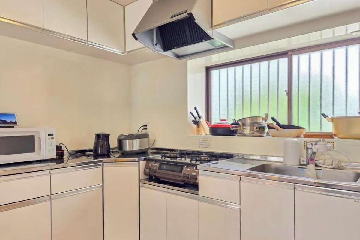 Una cocina moderna con microondas, estufa y distintos utensilios de cocina.