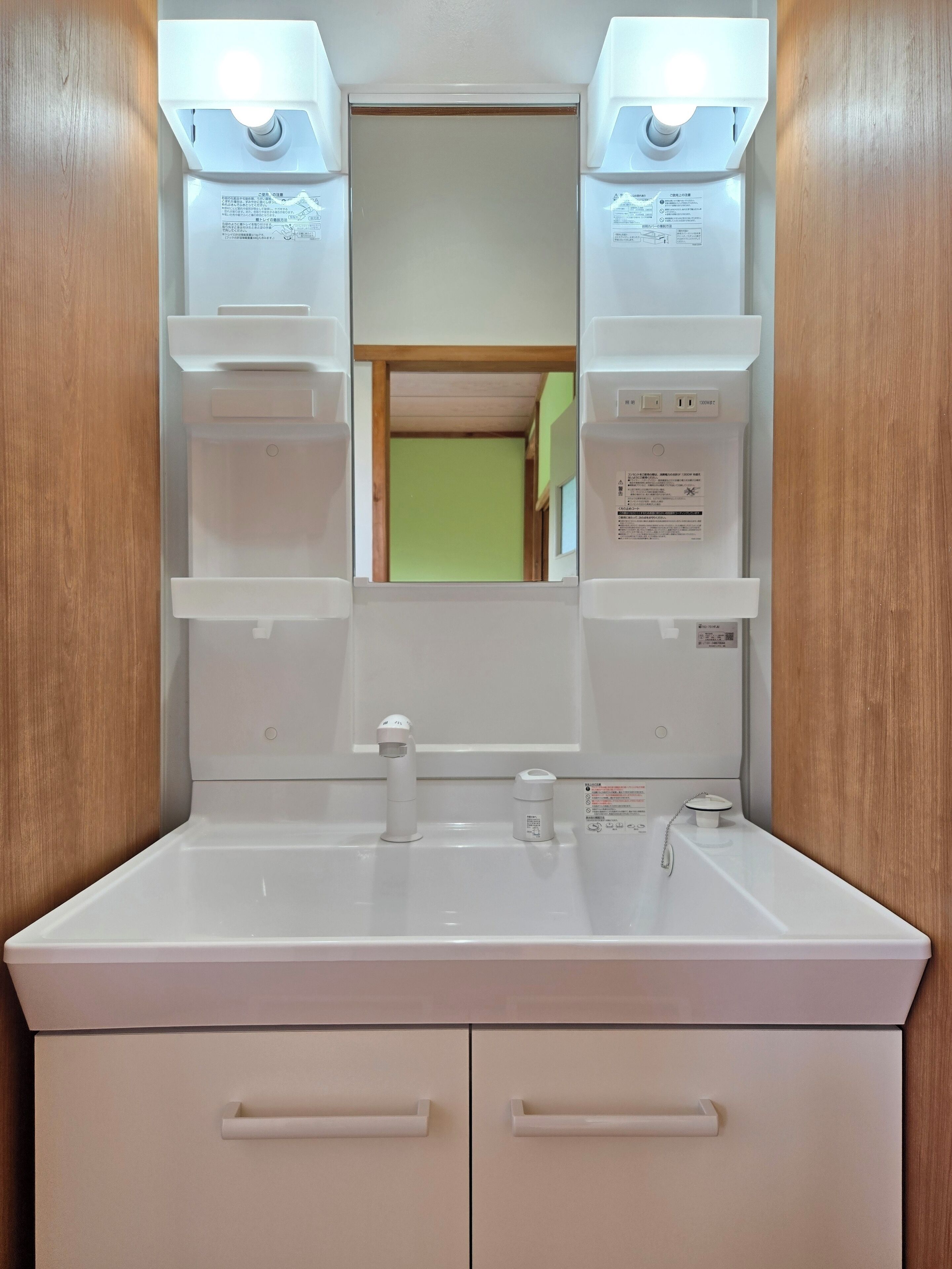 A bathroom with a white sink, mirror, and two cabinets below.