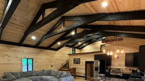 Un'ampia zona giorno con un grande divano componibile, un'area pranzo con sedie in legno e una cucina dotata di elettrodomestici moderni.
