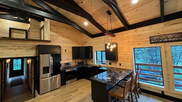 Una cucina moderna con pareti in legno, un'isola centrale e vista all'esterno.