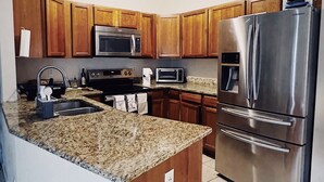 A modern kitchen with wooden cabinets, stainless steel appliances, and a granite countertop. -  Charming 3 bedroom home Centrally located in Worcester (Worcester)