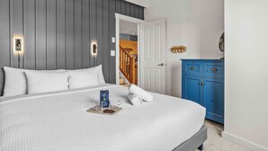 A bedroom with a bed, bedside table, and a blue cabinet. - Penthouse•King Beds•Pool•BikeStorage (Canmore)