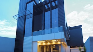 A modern building with a glass facade, a prominent entrance with a ramp, and a flat roof.