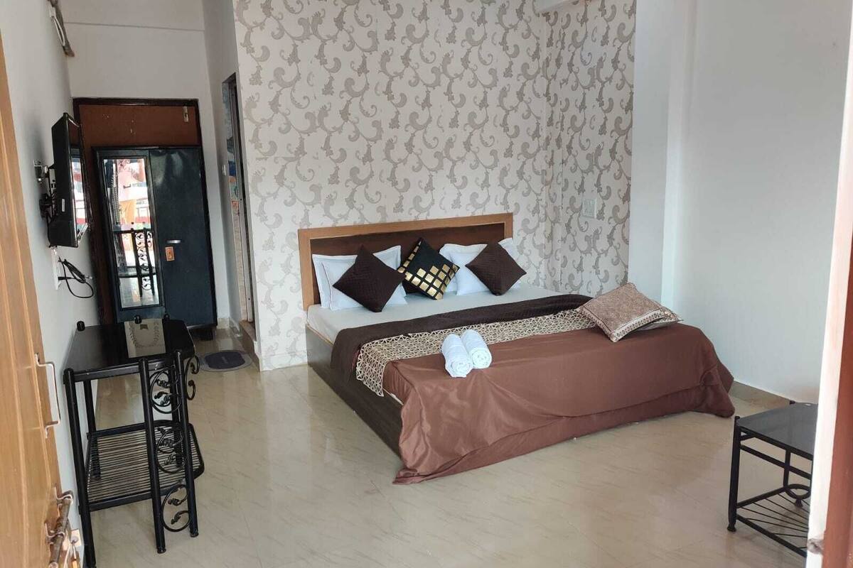 A bedroom with a bed, a desk, and a chair.