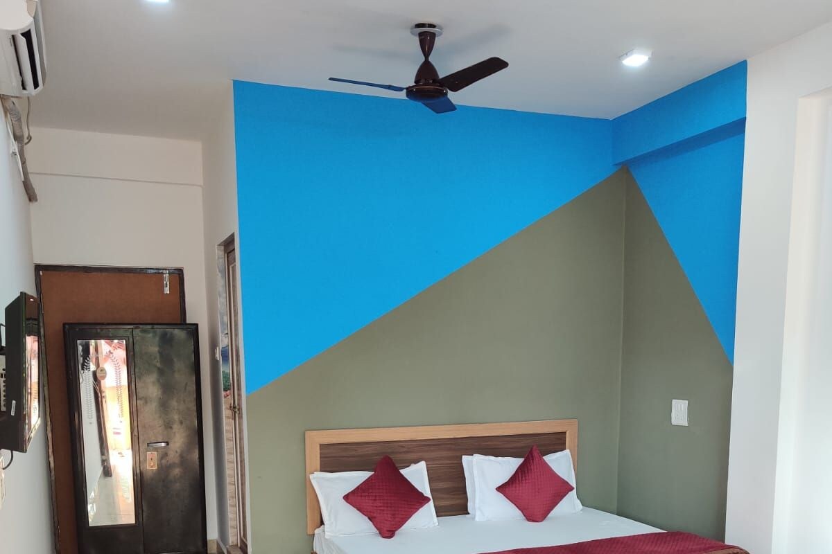 A bedroom with a bed, a ceiling fan, and a door.