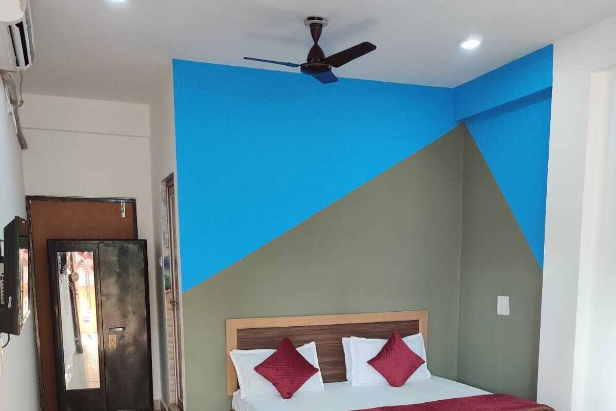 A bedroom with a bed, a ceiling fan, and a door.
