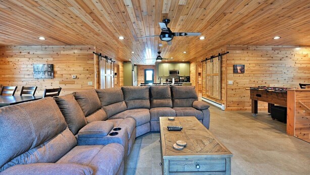A cozy living room with a sectional sofa, a coffee table, and a foosball table.