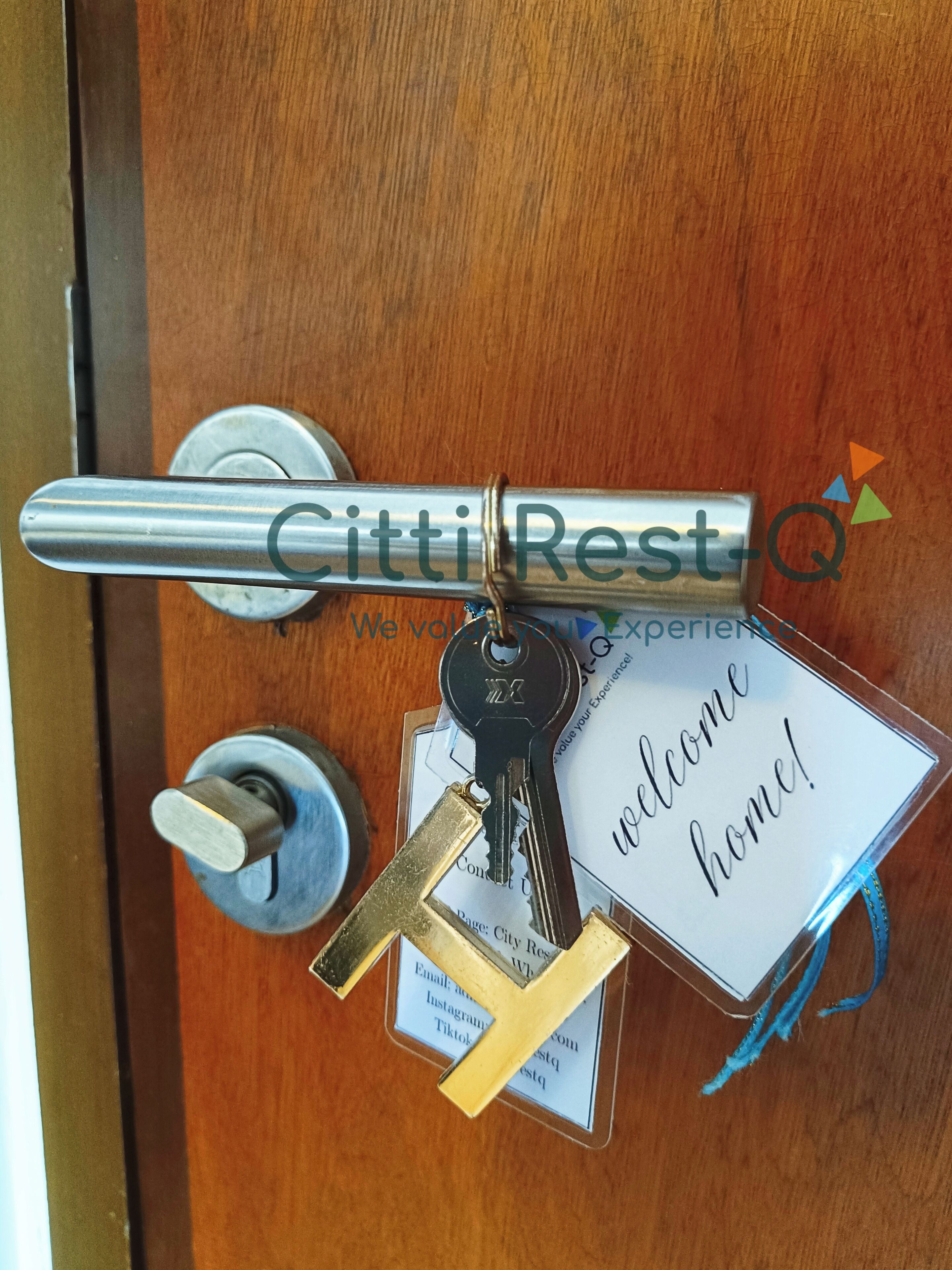 Una porta amb un penjador de claus que conté claus, un cartell de benvinguda i una targeta de visita.